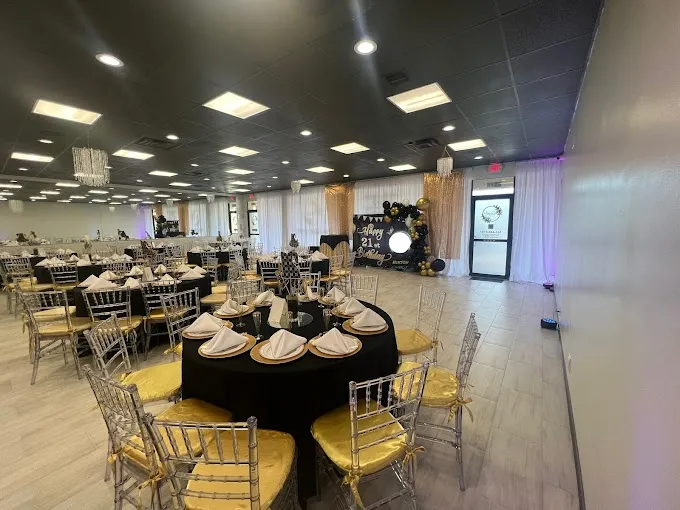 A wide view of the hall with round tables set in white and blush for a full-capacity event