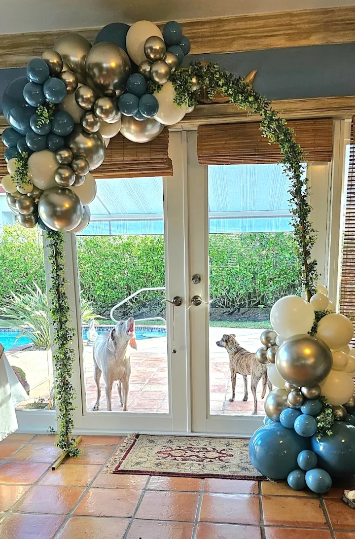 A navy, gold, and cream garland with trailing greenery arching over a doorway