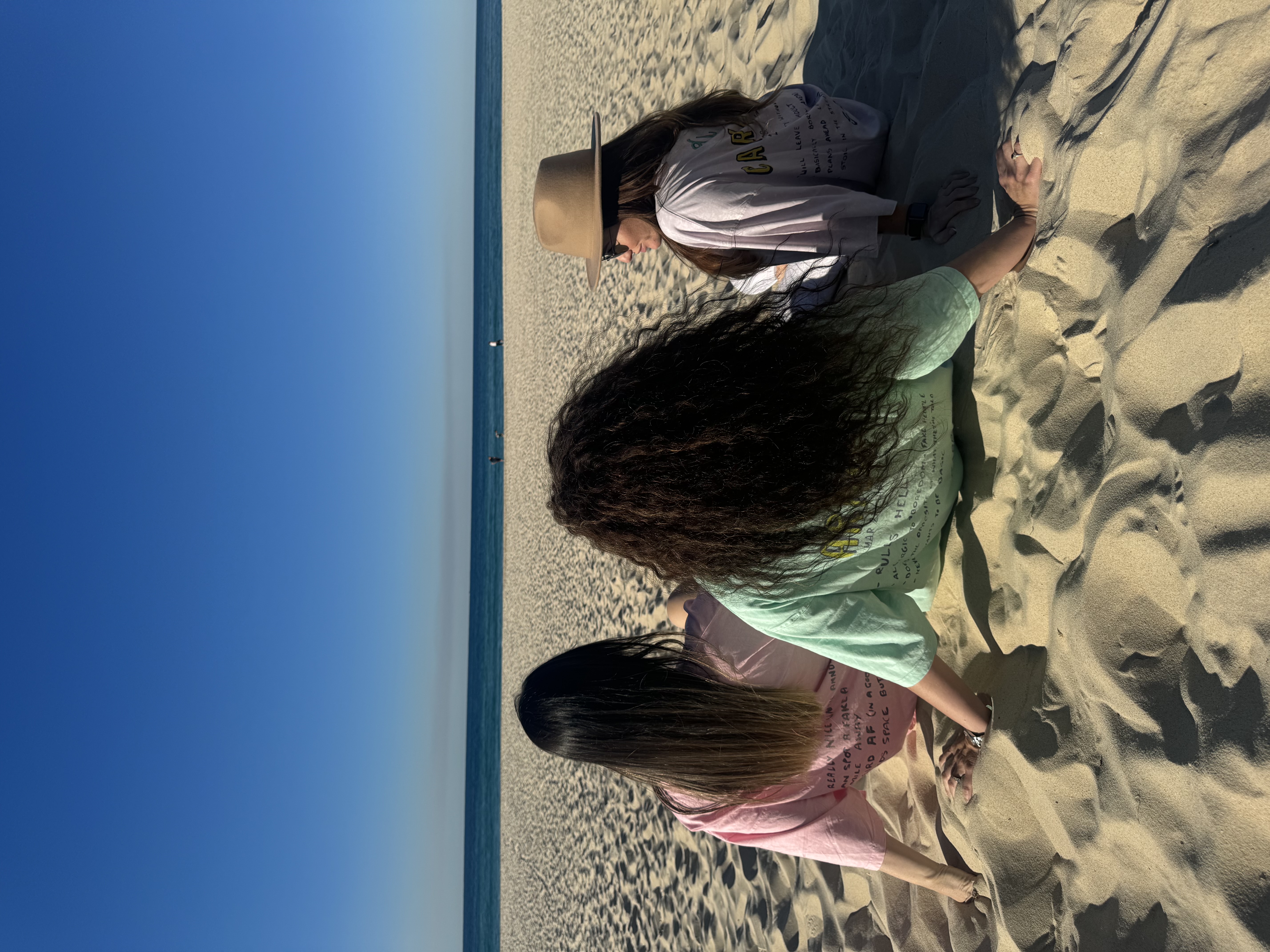 Three Mamas Down Under founders sitting together on an Australian beach