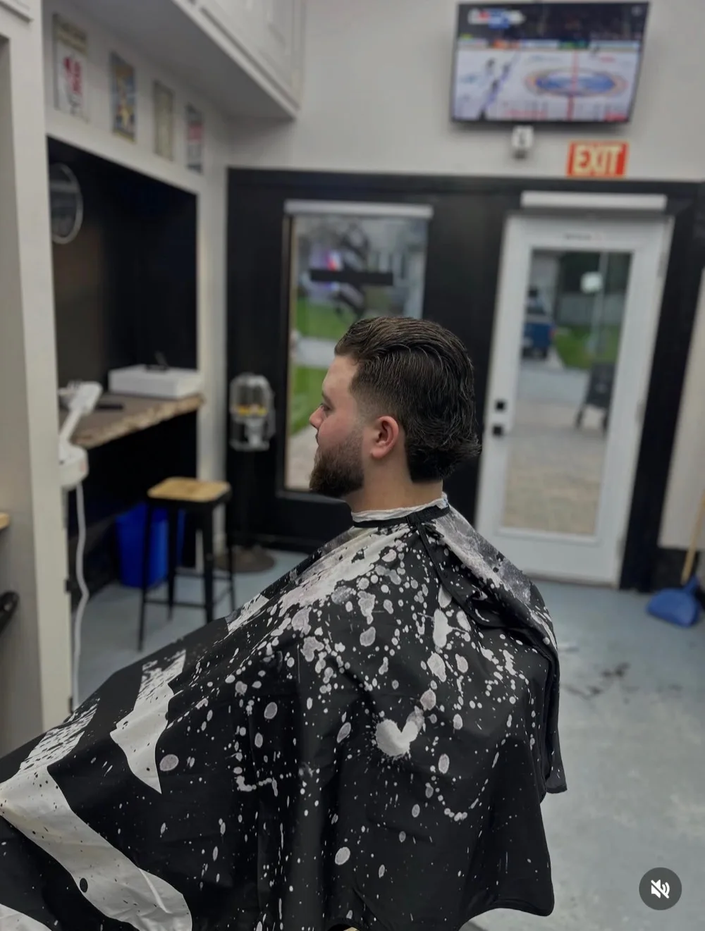Barber cutting hair in shop