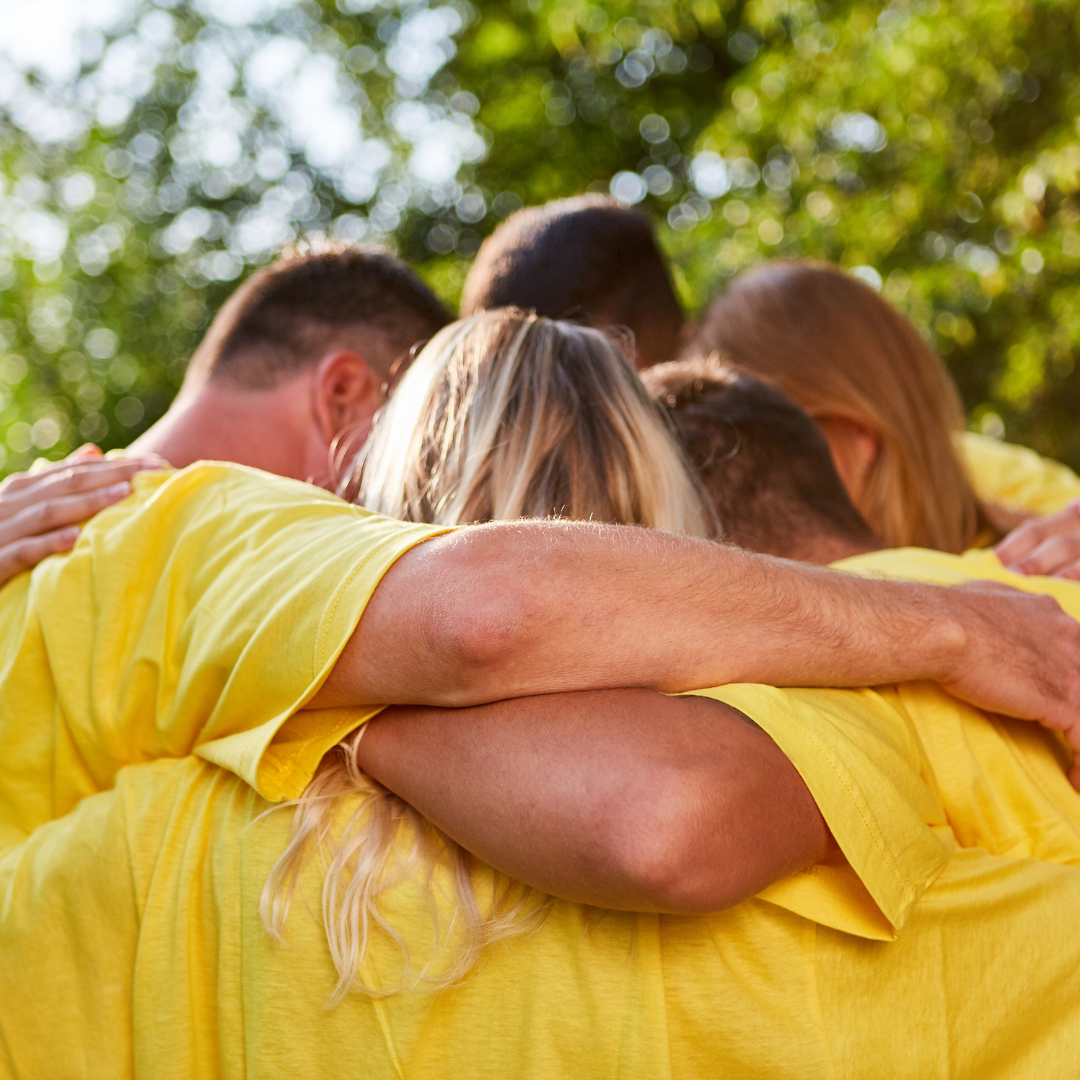 Group of people with arms around each other hugging and strategizing for game time
