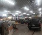 Wide view of Mundt's Auto garage with multiple vehicles being serviced