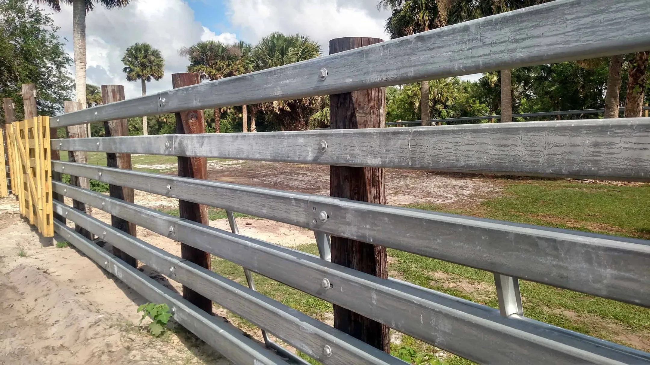 Galvanized rub rail C-channel stacked in a yard
