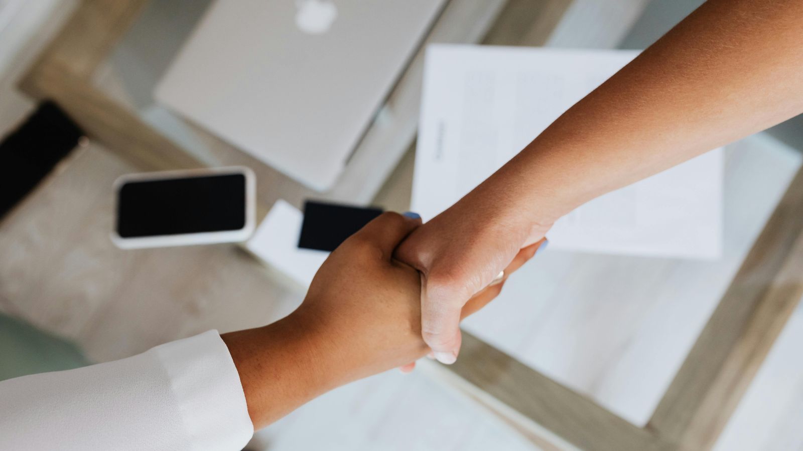 Business owner shaking hands with a financial adviser after discussing life insurance options. Business owner shaking hands with a financial adviser after discussing life insurance options.
