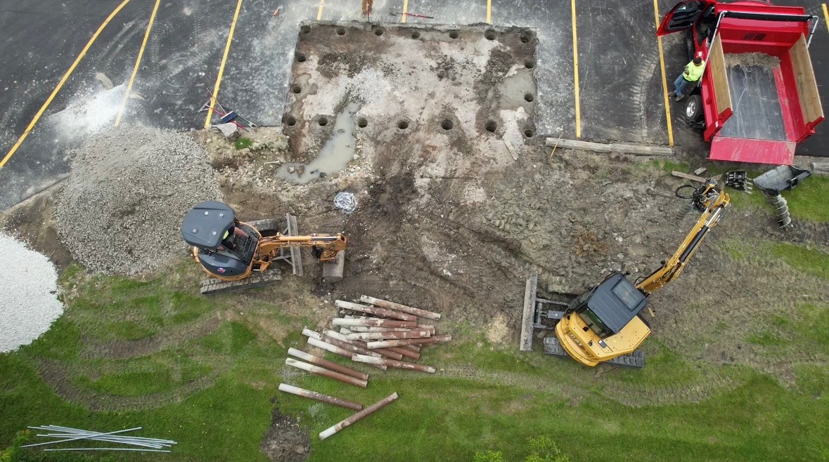 Excavators breaking concrete and preparing parking lot for commercial excavation project
