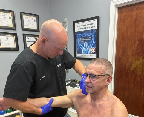 Dr. Brian Petrie performing shoulder pain evaluation for rotator cuff condition in Raynham MA