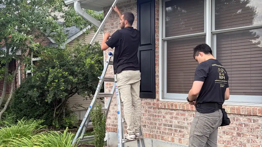 Mid Mo Glow crew installing permanent lighting track on a brick home