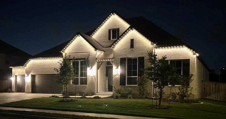 Brick home outlined in warm white permanent LED lighting at night