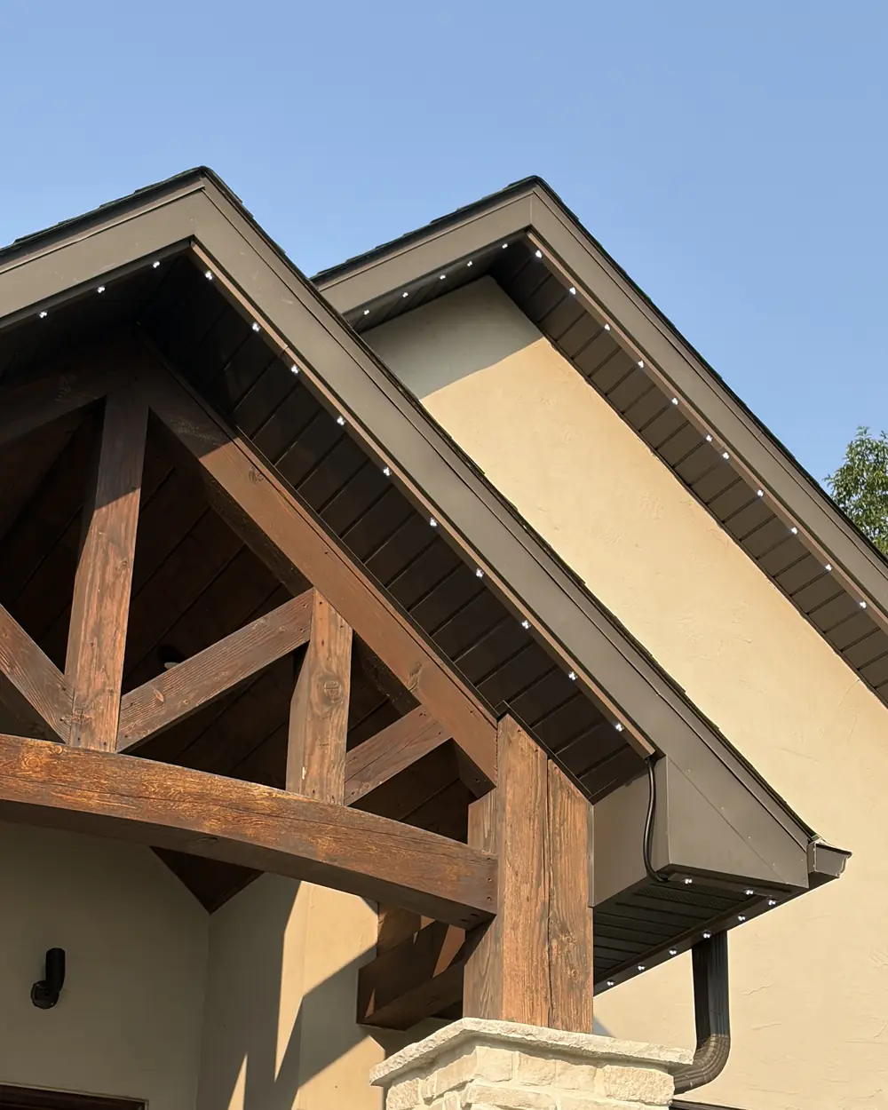 Color-matched permanent lighting track along a gable in daylight