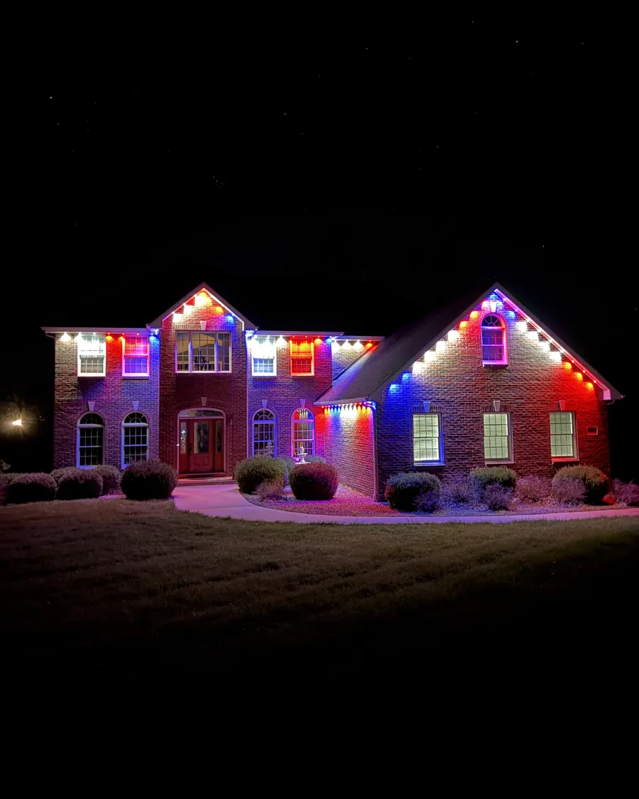 Brick home lit in red, white, and blue permanent lights