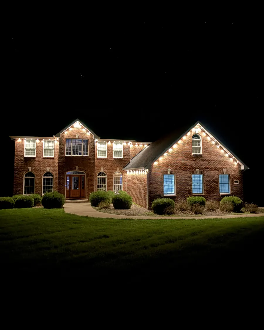 Brick home lit in multicolor permanent LED lighting at night