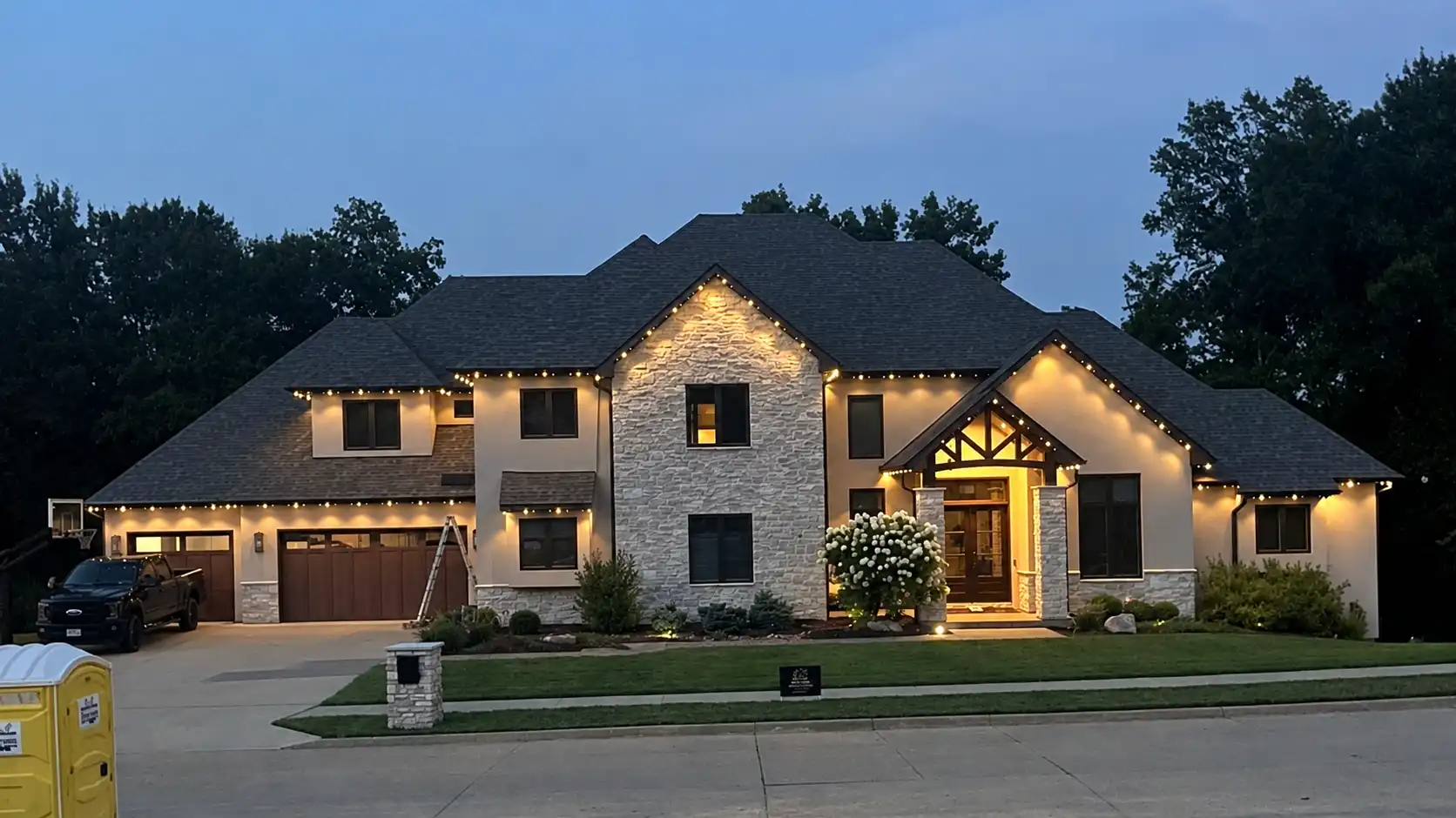 Two-story home with warm white Signature permanent lighting at night