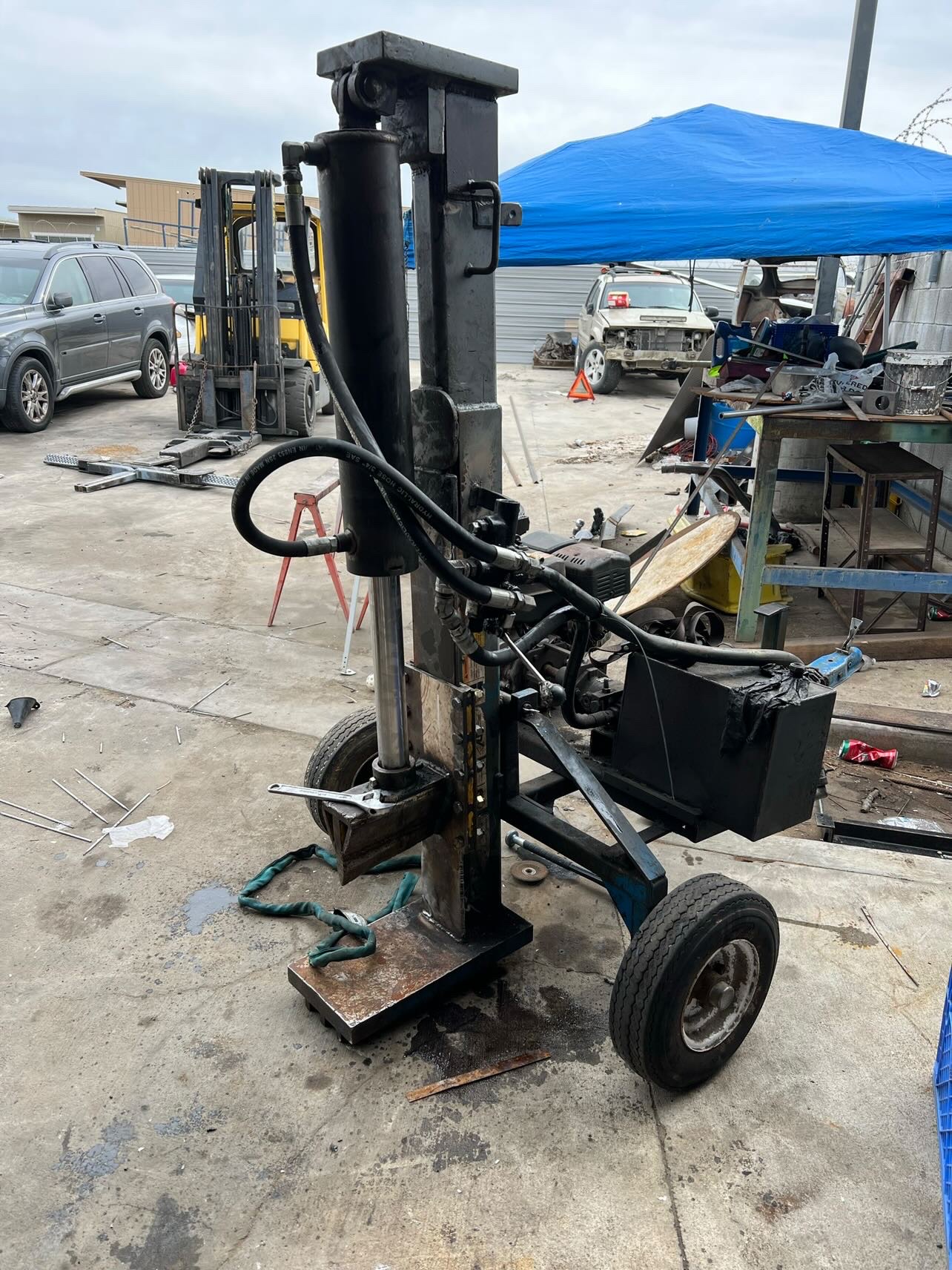 Custom fabricated portable hydraulic log splitter with steel frame and wheels, built by professional welders in Southern California