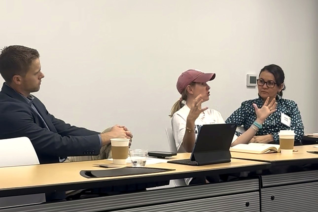 Two owners talking through an idea while others listen