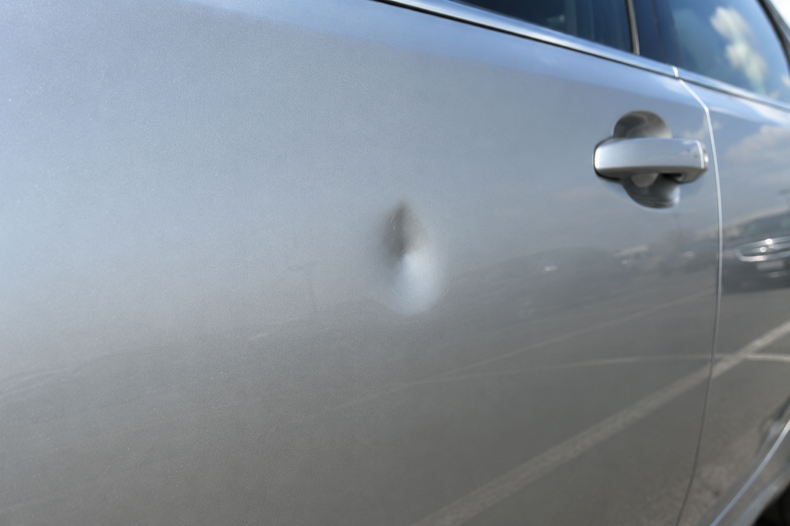 Door ding dent on car panel showing when paintless dent repair is needed in Edmonton