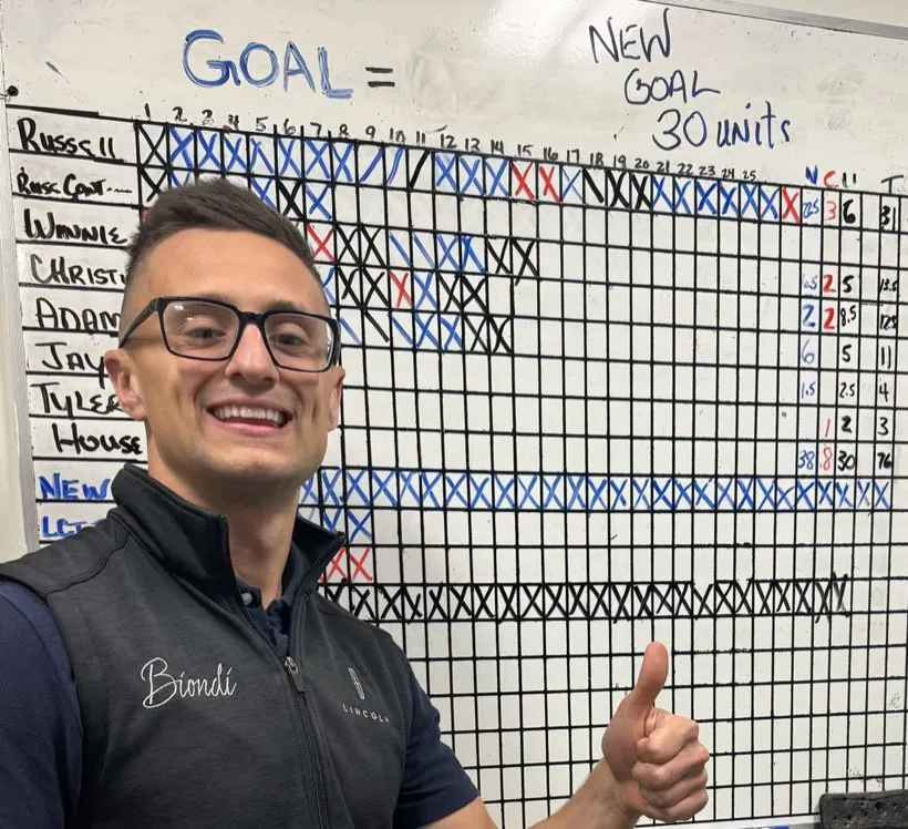 Russ at his store's sales board during a 30-unit month