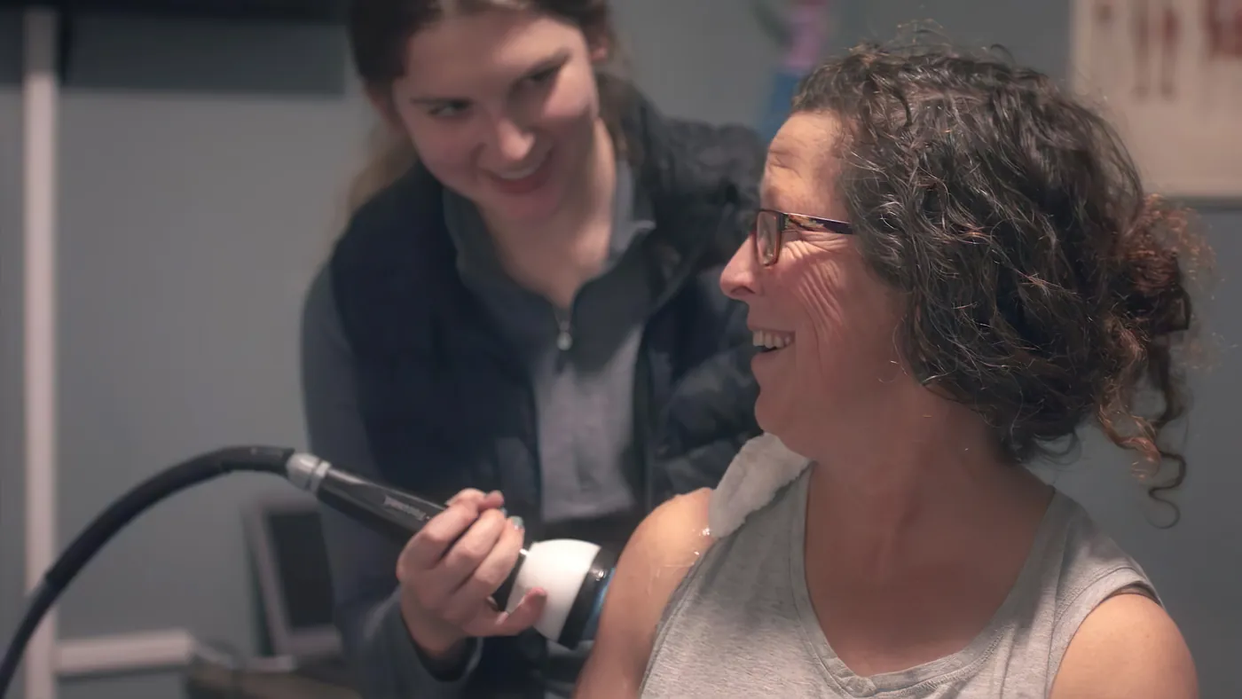 Patient smiling during a StemWave session with her clinician