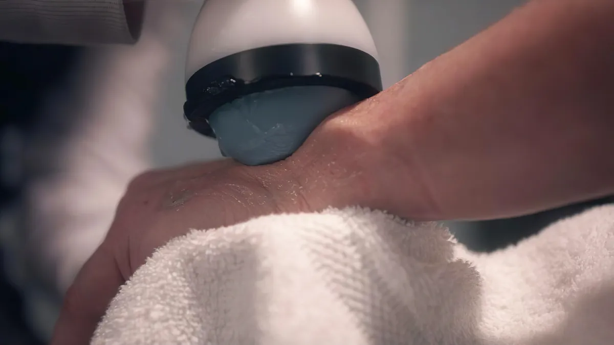 Clinician treating a patient's forearm with the StemWave applicator in a calm treatment room