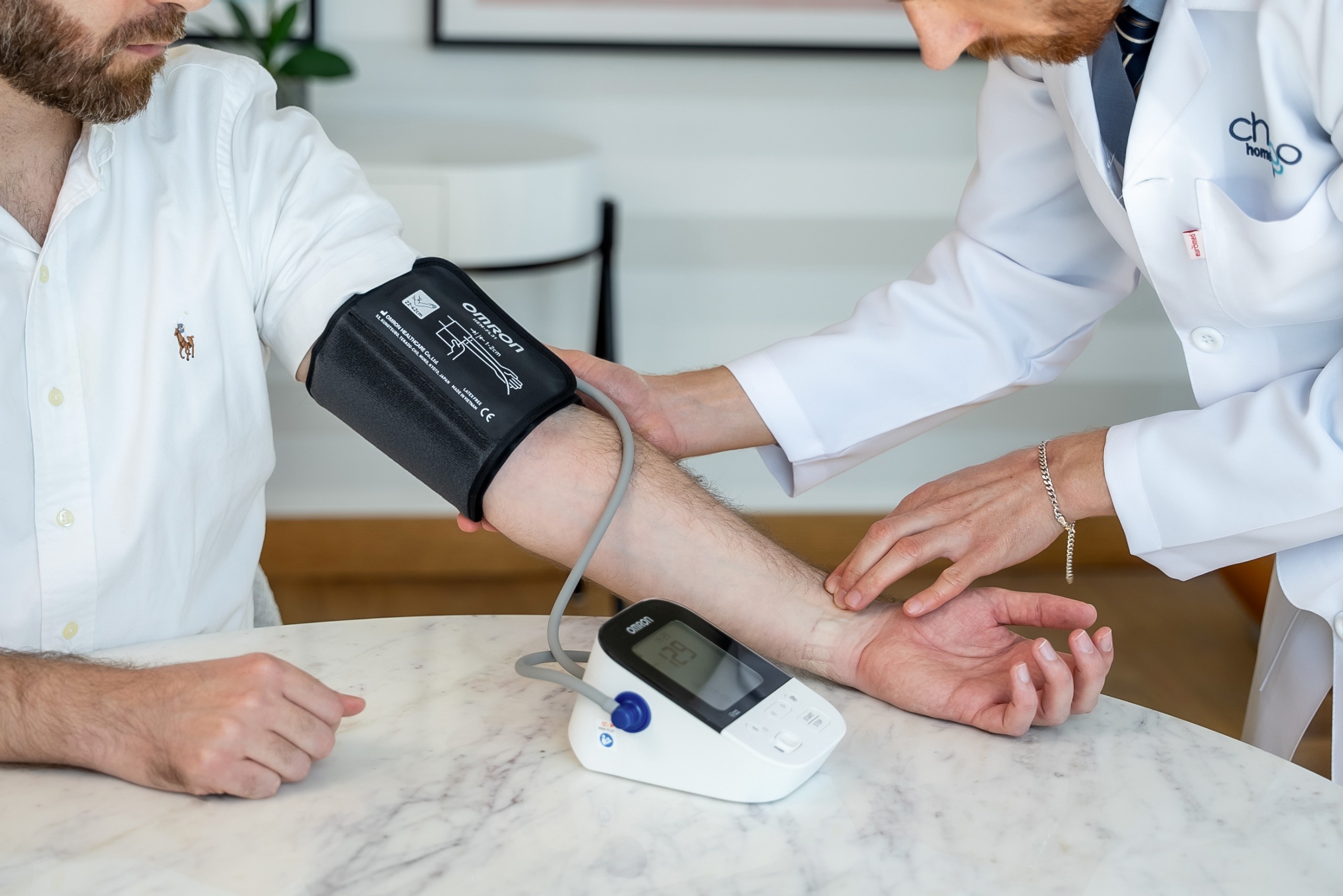 Doctor at home checking blood pressure