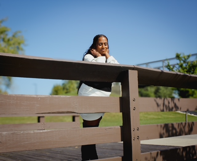 Camille Janei Swoope resting on a bridge railing