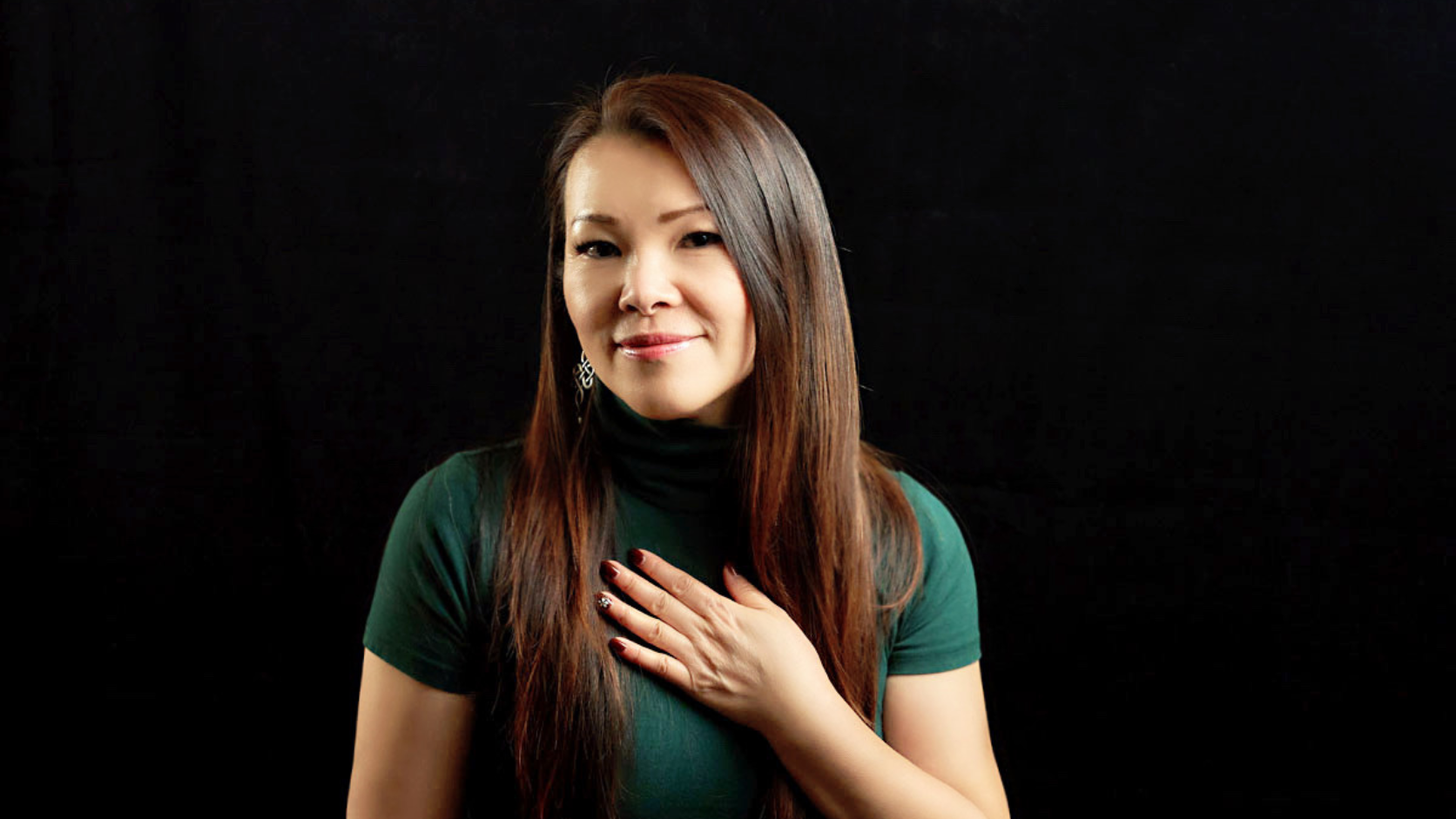 Riya Wang with her hand on her heart, warmly welcoming students into the journey