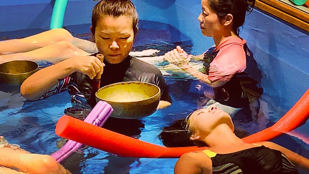 Students practicing sound healing together during certification training