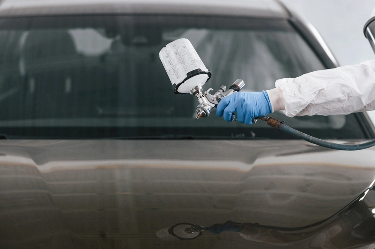 Mechaniker trägt frische Lackierung auf Auto in der Werkstatt ATW Auto Technik Wandsbeck auf