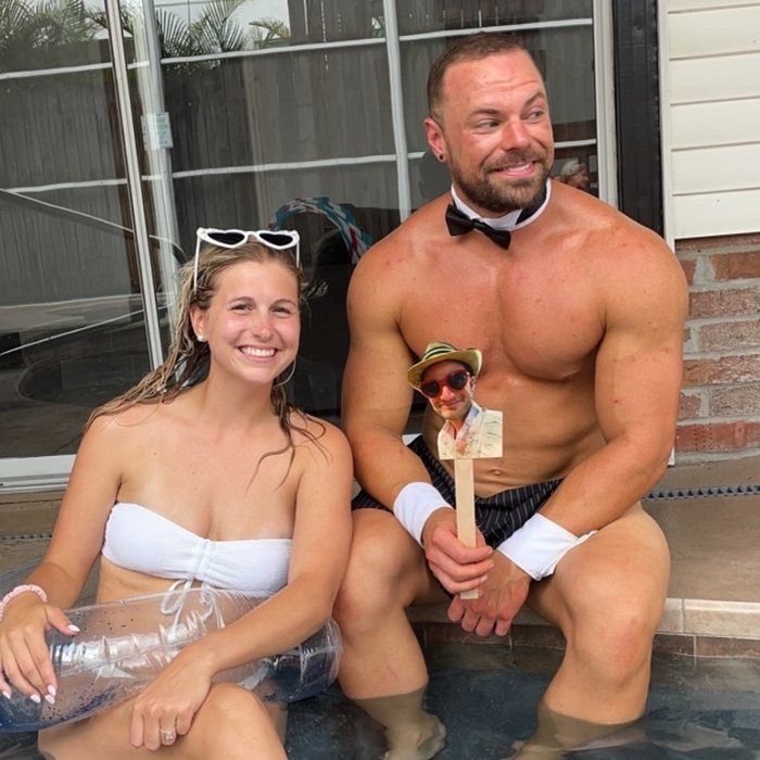 A Cheeky Butler poolside with a guest, swim shorts on, mild setting