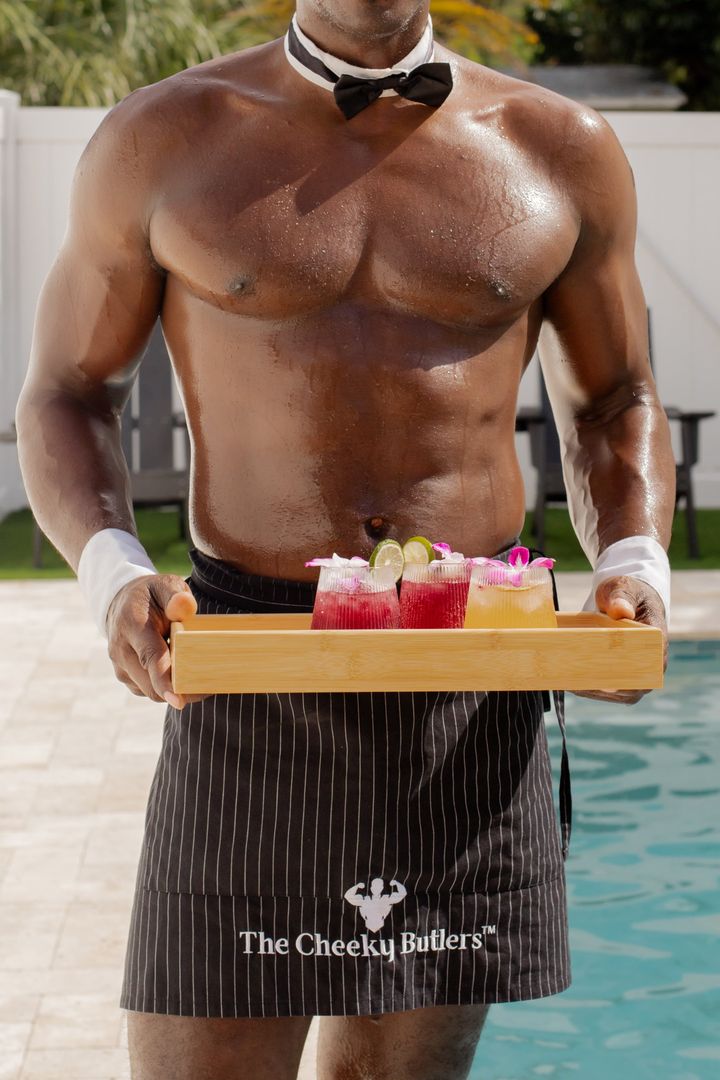 A Cheeky Butler carrying a tray of cocktails beside the pool