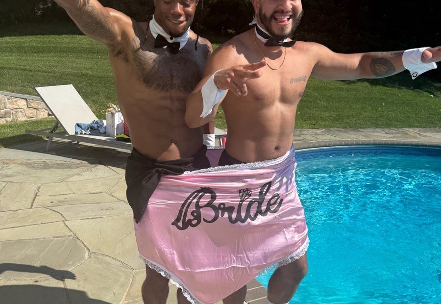 Two Cheeky Butlers holding a pink Bride apron poolside