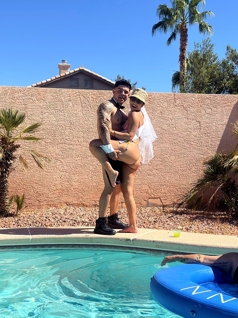 Cabana boy lifting the bride at a poolside bachelorette party