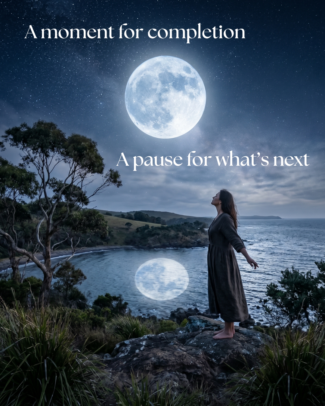A woman stands on a rugged, grassy headland overlooking a calm ocean bay under a starry night sky, looking up at a massive, glowing full Blue Moon