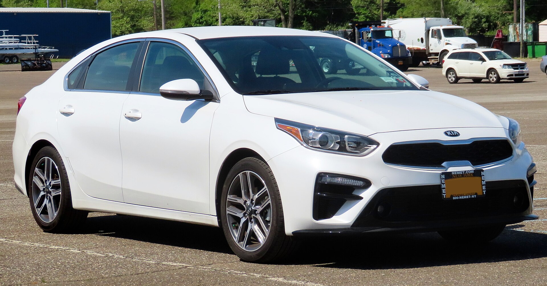 A white Kia Forte EX sedan, front three-quarter view
