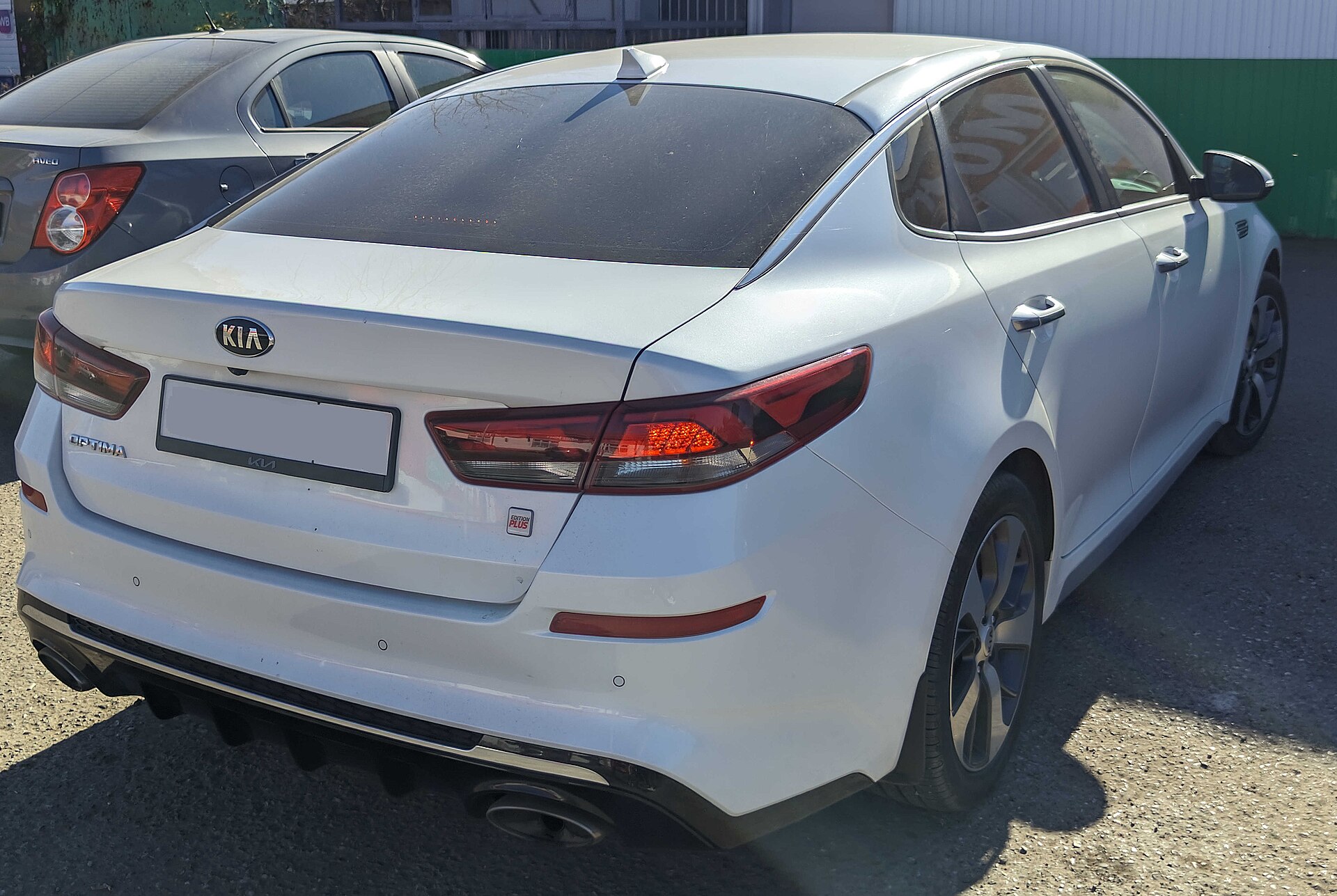 A white Kia Optima sedan, rear view