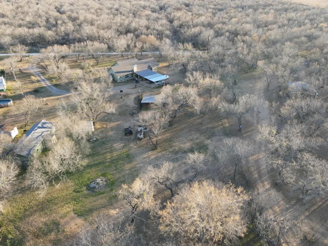 Aerial photography Texas Hill Country sprawling property overview with native oak trees and rolling terrain