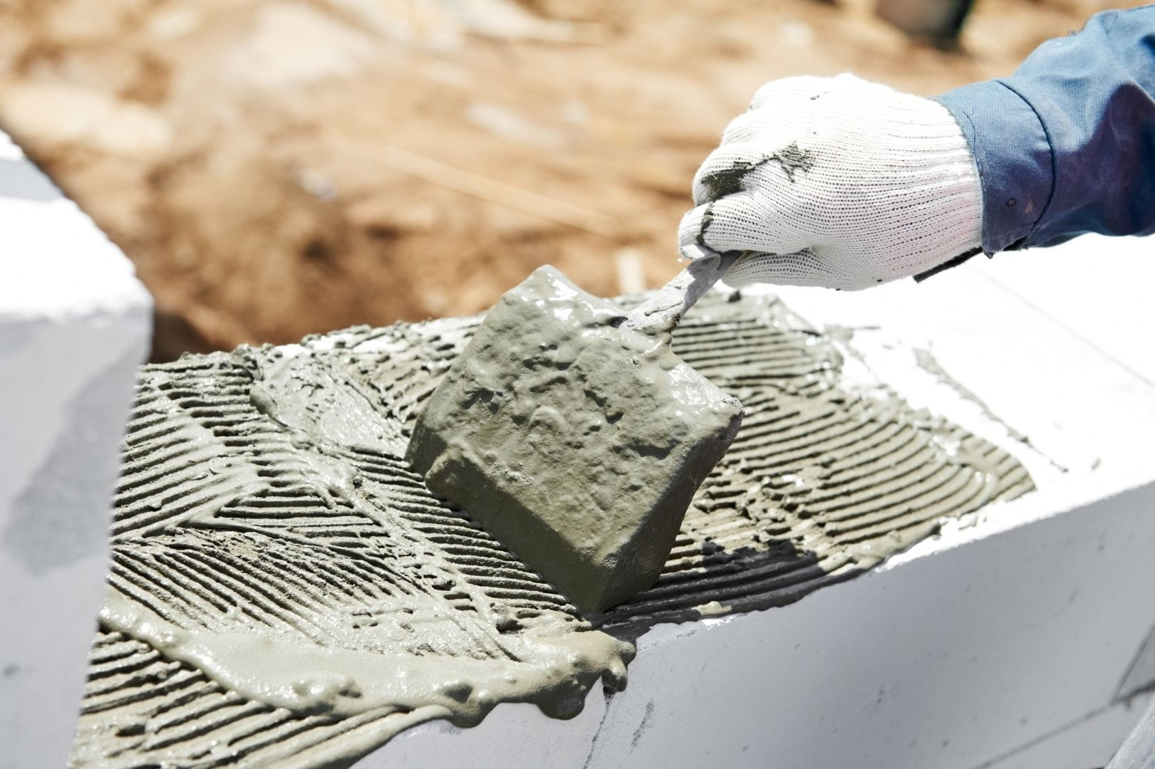 Application de mortier pour le montage d'un mur en blocs lors de travaux de construction et de maçonnerie générale à Dreux.