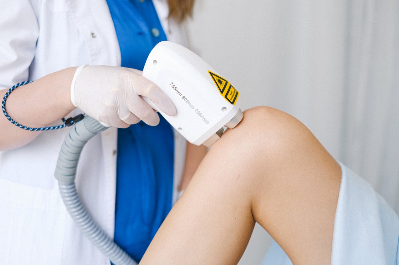 Laser therapy treatment being performed on a patient's knee by a professional in a medical clinic. Laser therapy treatment being performed on a patient's knee by a professional in a medical clinic.