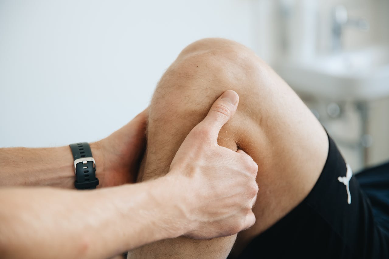 Close-up of a physiotherapist massaging a patient's knee during therapy. Close-up of a physiotherapist massaging a patient's knee during therapy.