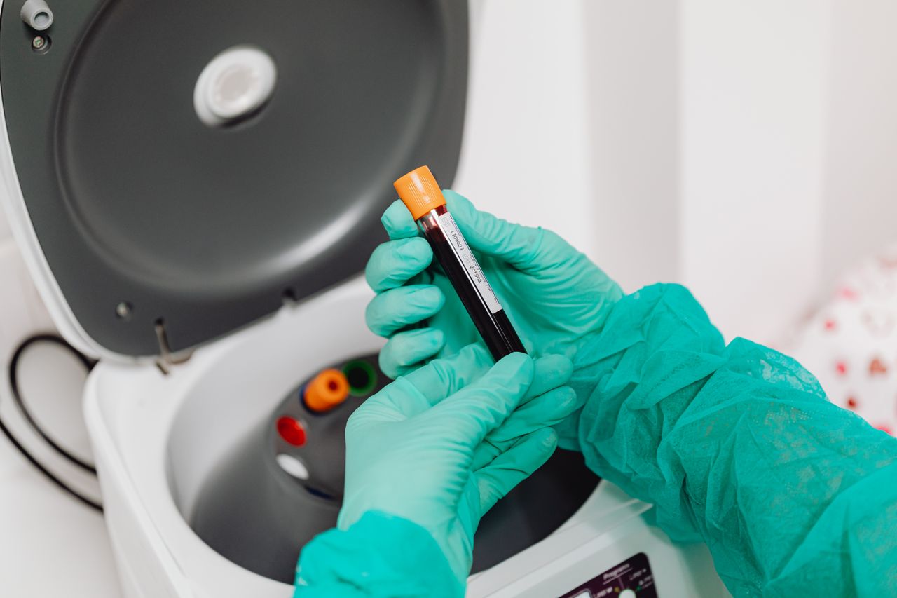 Laboratory scene with a healthcare professional preparing a blood sample for analysis using a centrifuge. Laboratory scene with a healthcare professional preparing a blood sample for analysis using a centrifuge.