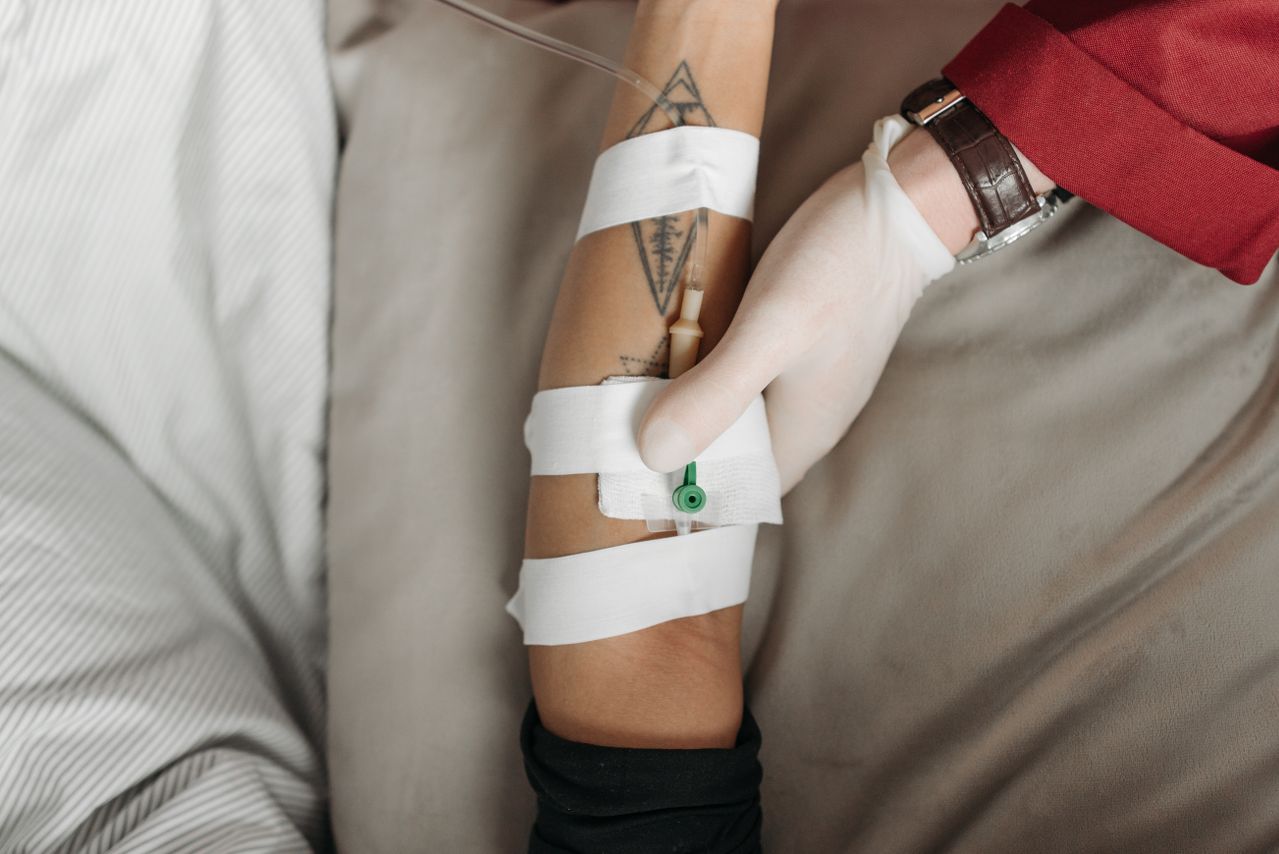 Close-up of a healthcare worker administering an IV to a patient's arm, focusing on the medical procedure. Close-up of a healthcare worker administering an IV to a patient's arm, focusing on the medical procedure.