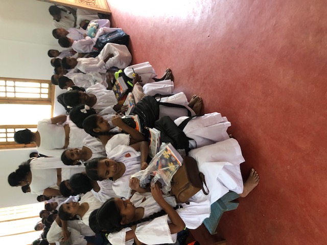 Children attending school supply distribution after cyclone relief effort in rural Sri Lanka