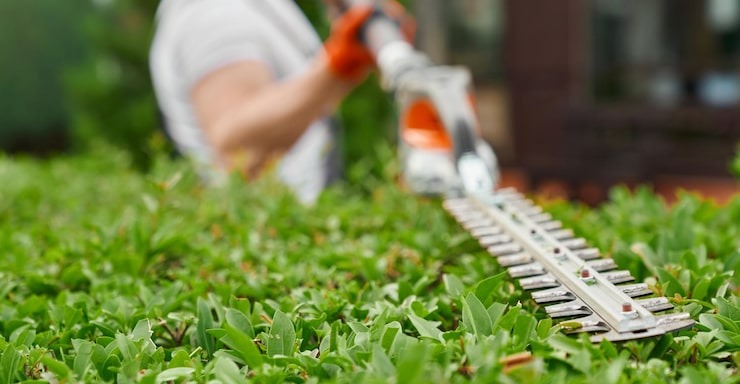 An SGJ Landscaping professional operating a lawn mower in a residential backyard in Honesdale, PA.