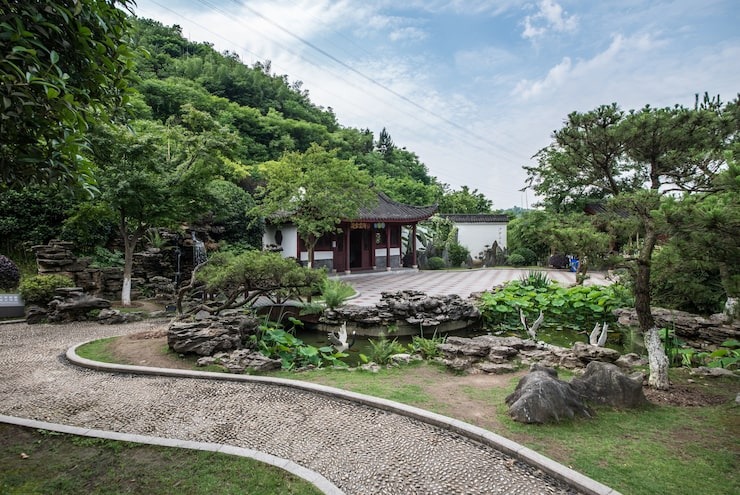 Curved gravel garden pathway with decorative rocks, shrubs, and landscaped greenery.