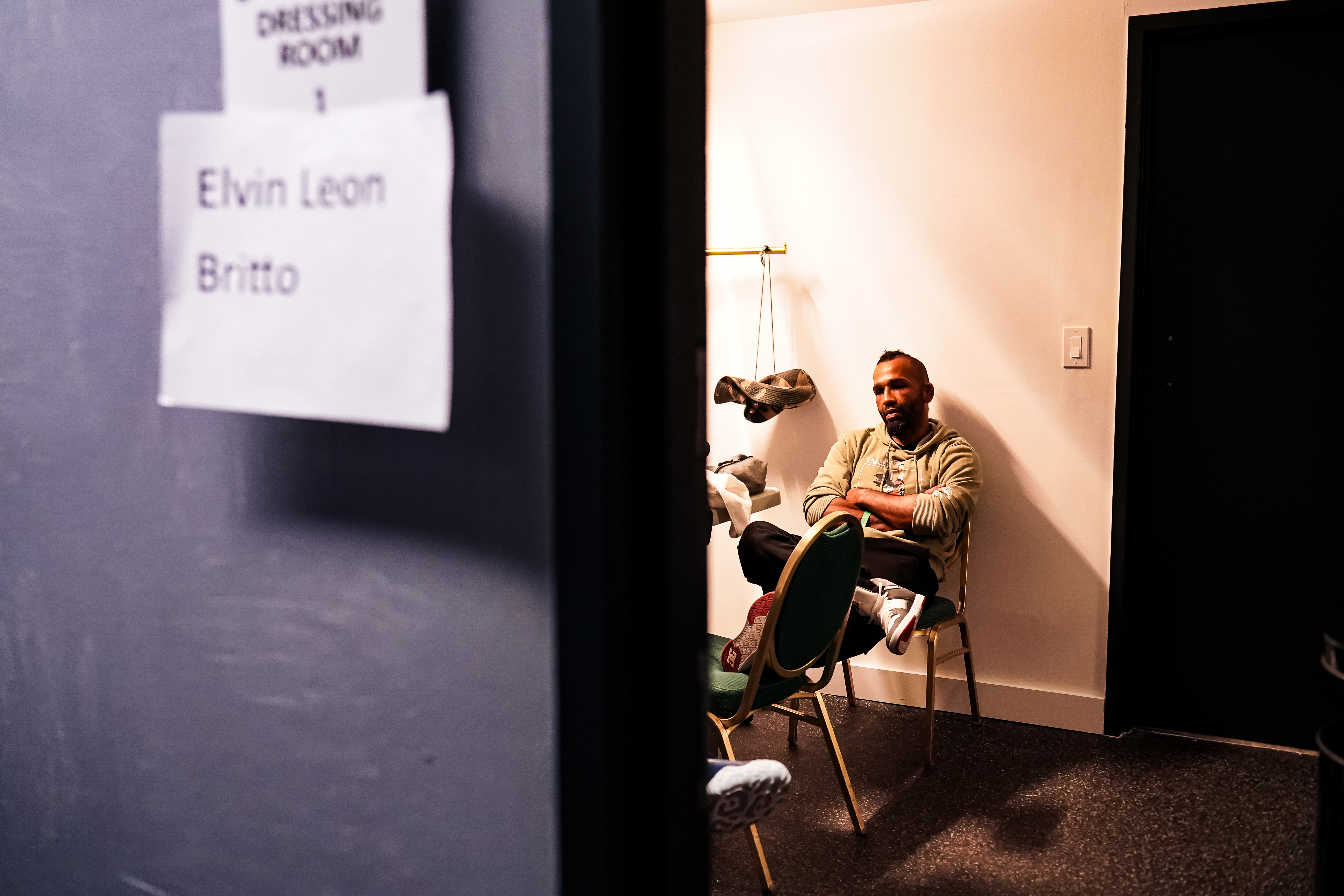 Fighter sitting calmly in the locker room talking with his coach before his main event fight