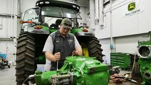 Mechanic repairing John Deere tractor engine