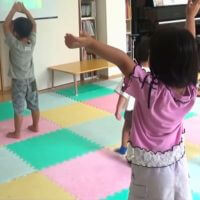 動画に合わせて歌ったり踊ったりするリトミック教室の子どもたち