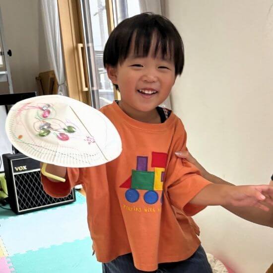 リトミック教室で作った作品を笑顔で見せる男の子