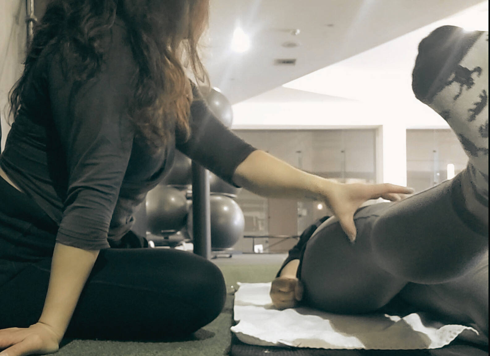 Geni Perez coaching a client through hip and leg mobility work