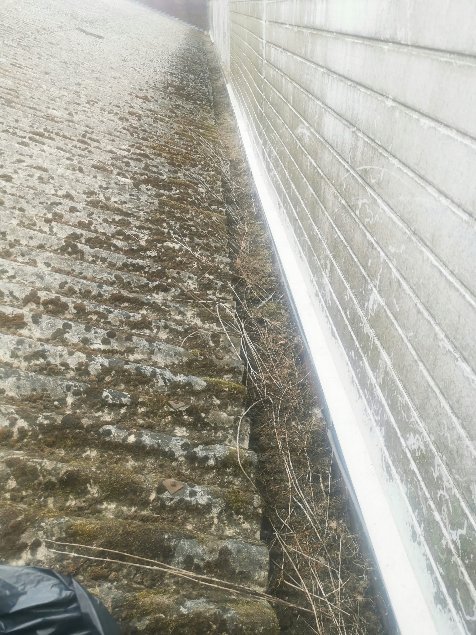 Valley gutter full of debris before cleaning
