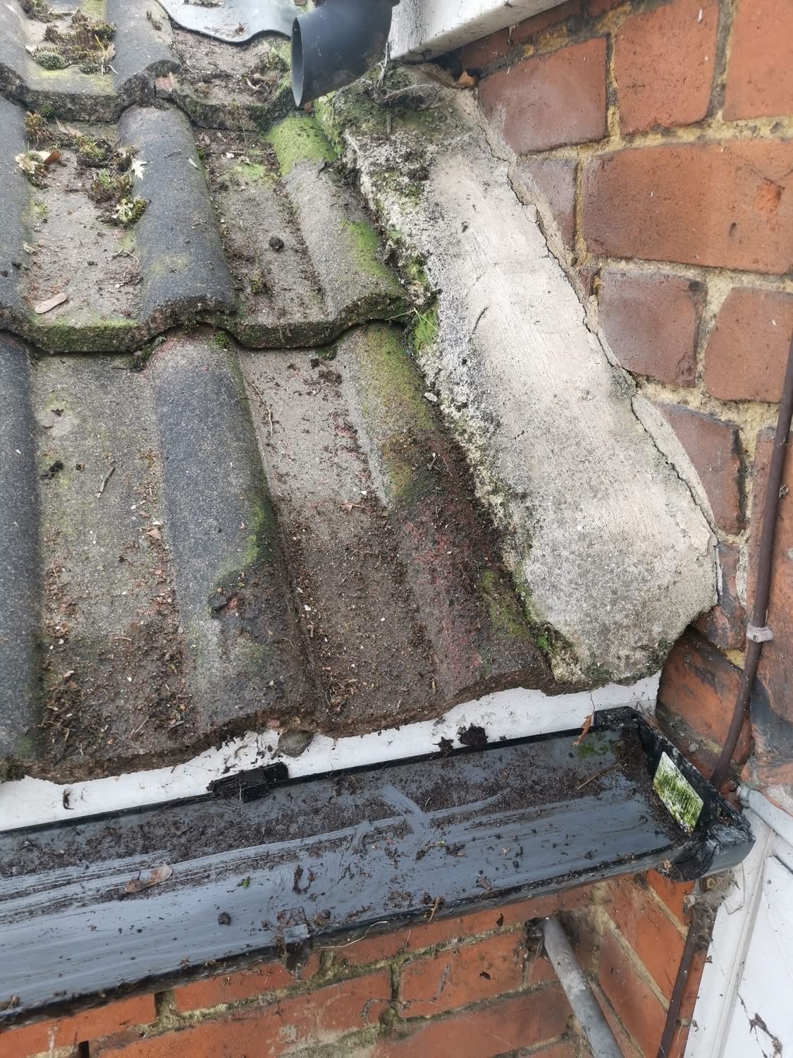 The same gutter cleared and flowing after cleaning